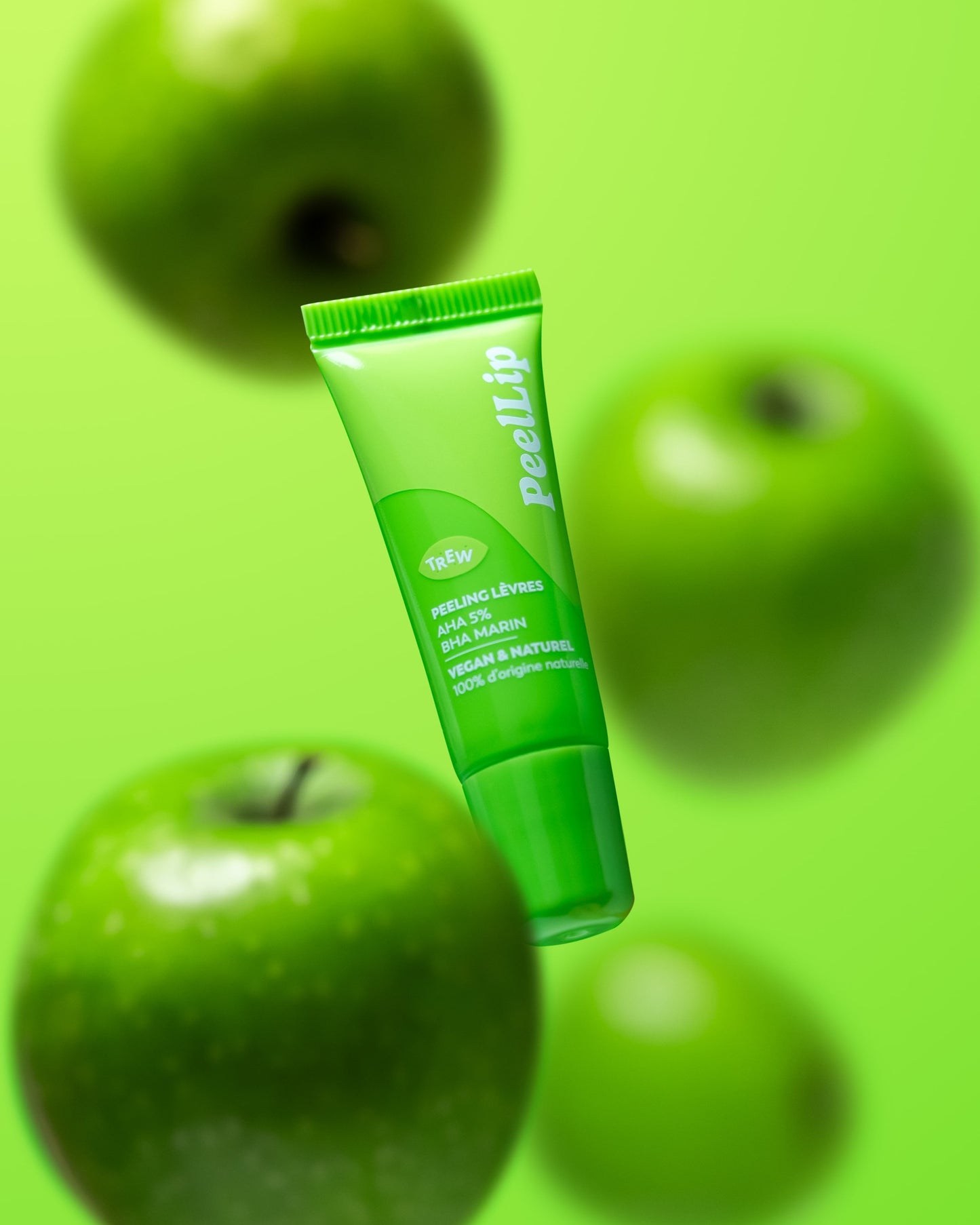 Bright green lip peeling tube labeled "PeelLip" floating against a vibrant green background with blurred green apples.