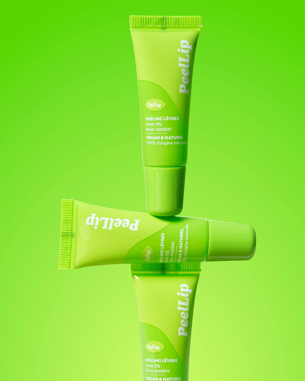 Three vibrant lime-green cosmetic tubes of PeelLip exfoliant stacked vertically against a matching neon green background.
