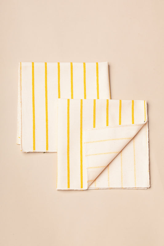 Servilletas de algodón blanco con rayas amarillas, de estilo moderno y ligero, ideales para comedor.