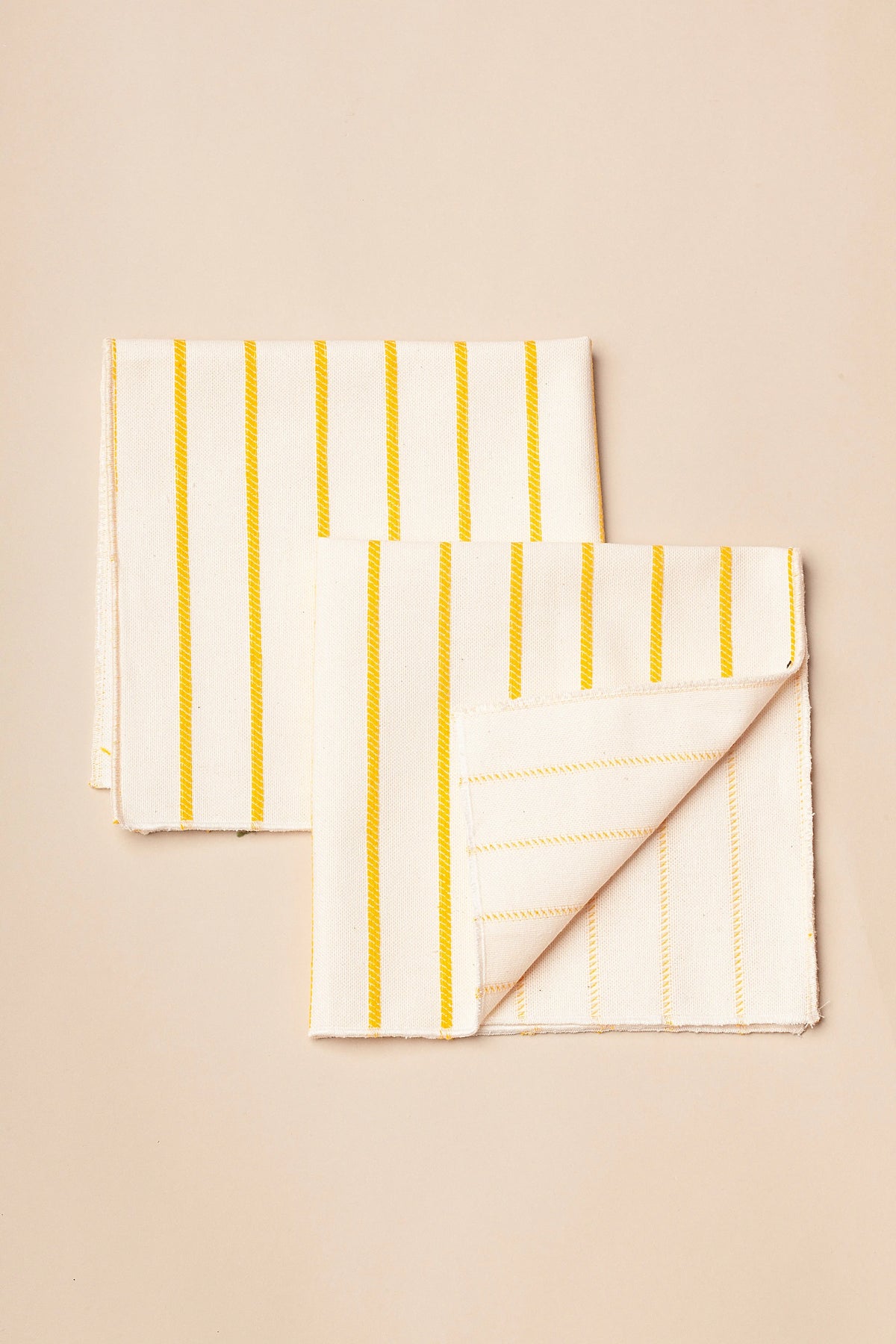 Servilletas de algodón blanco con rayas amarillas, de estilo moderno y ligero, ideales para comedor.