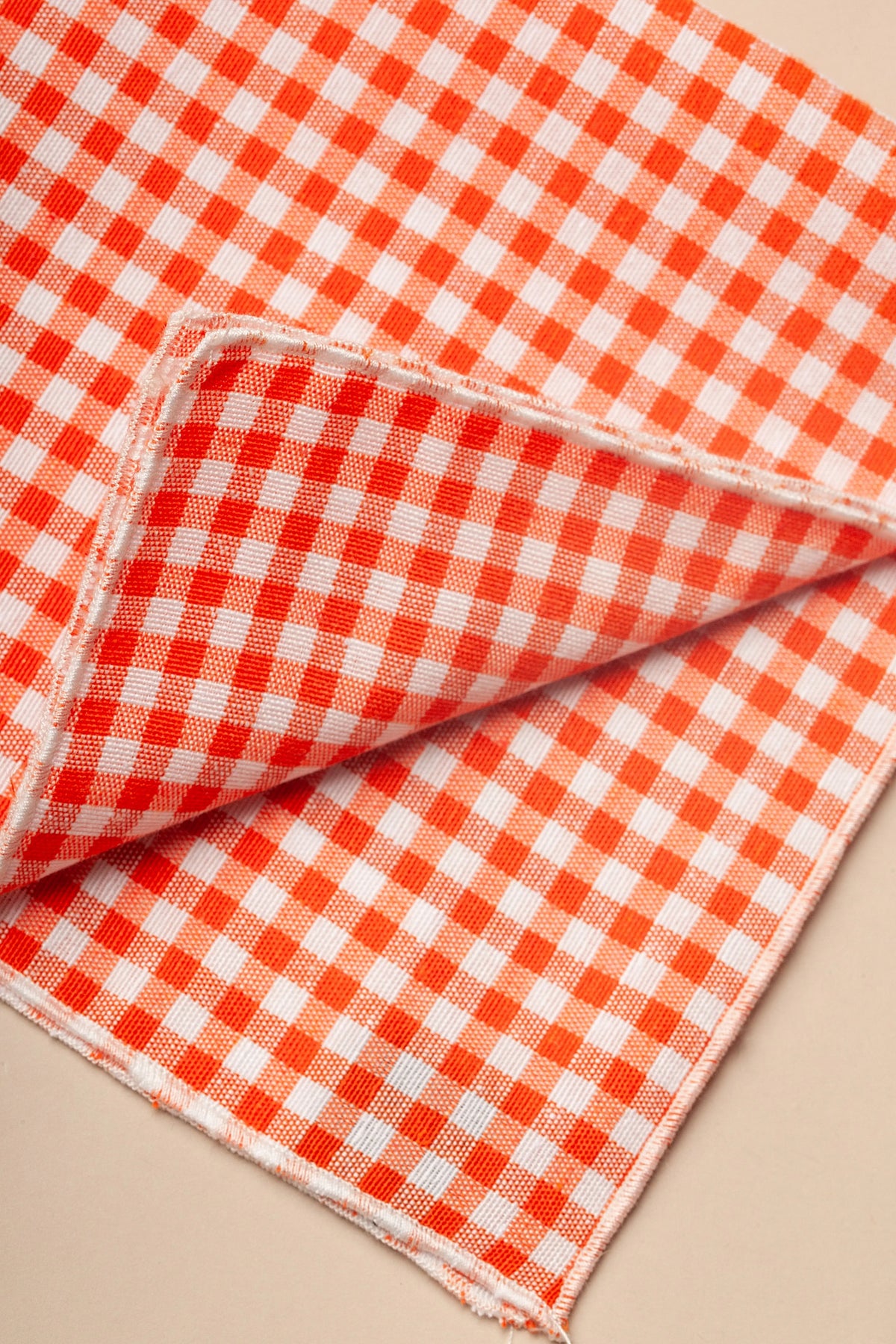 Pack de dos servilletas de tela con estampado de cuadros vichy en color naranja y blanco, estilo rústico y casual.