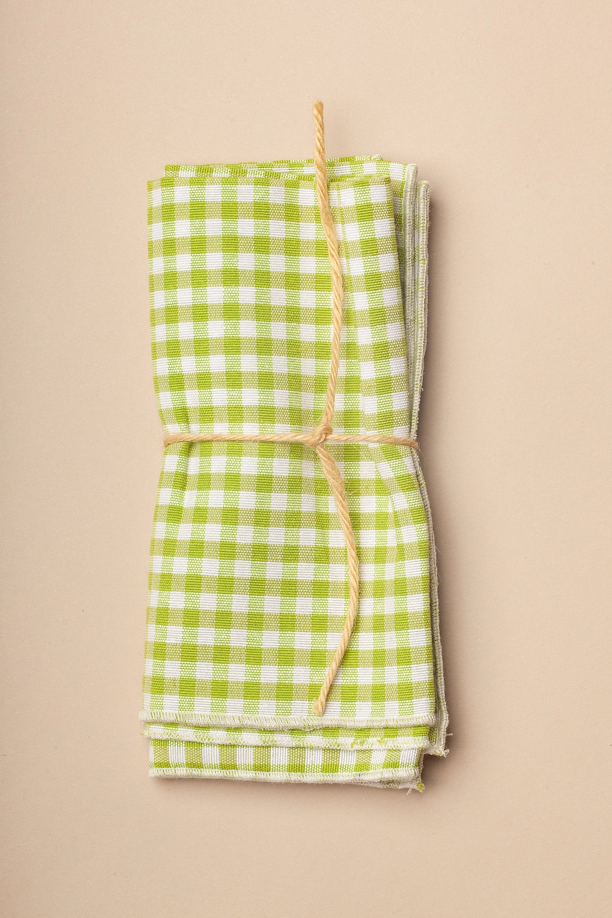 Pack de 2 servilletas de tela con estampado de cuadros vichy en color verde y blanco, atadas con una cuerda rústica.