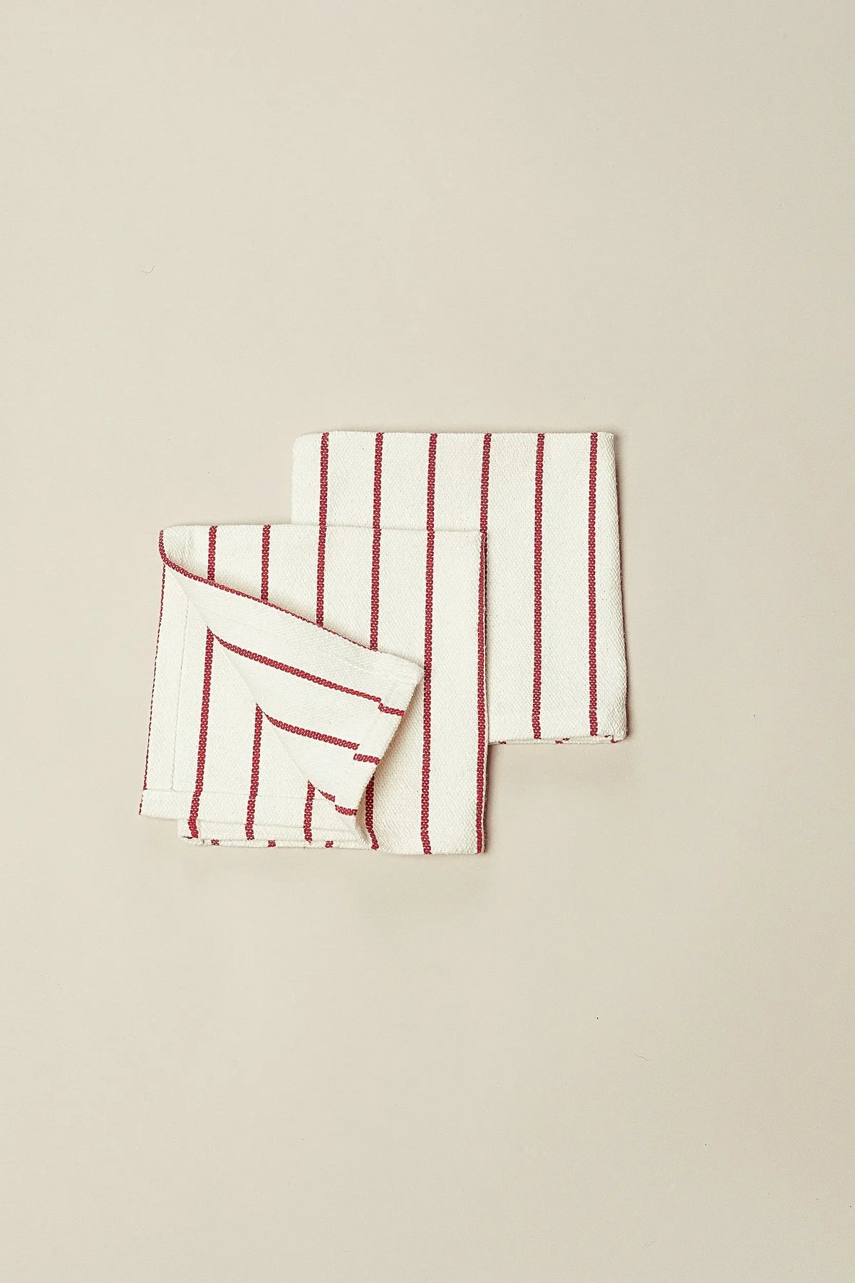 Pack of two off-white canvas napkins with vertical maroon stripes, folded on a neutral background.
