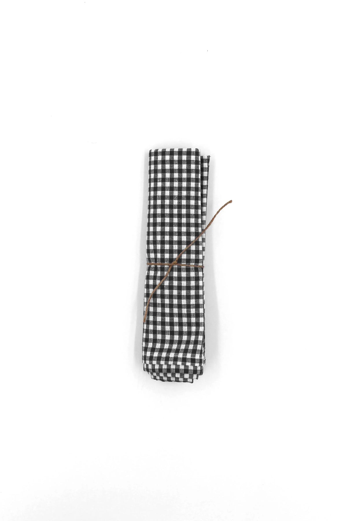 Pack de dos servilletas de tela con estampado de cuadros vichy en blanco y negro, atadas con una cuerda rústica.