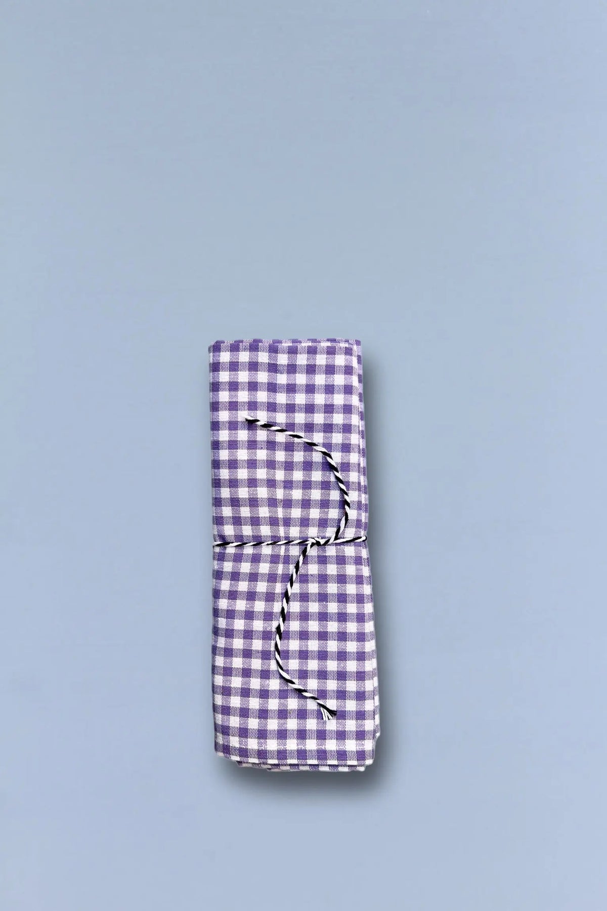 Pack de dos servilletas de tela con estampado de cuadros vichy en color malva y blanco atadas con un cordel fino.