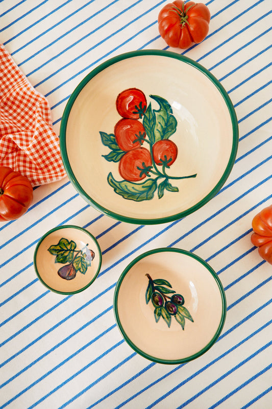 Set de tres cuencos de cerámica artesanal con motivos vegetales pintados a mano sobre fondo crema y borde verde.