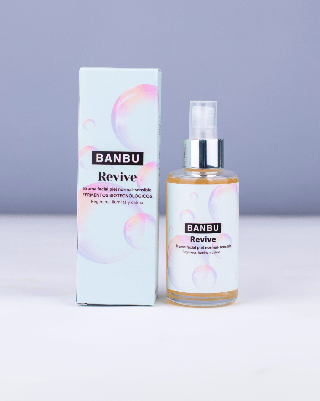 Tónico facial Banbu Revive en envase de cristal y caja azul claro con burbujas iridiscentes sobre fondo suave.
