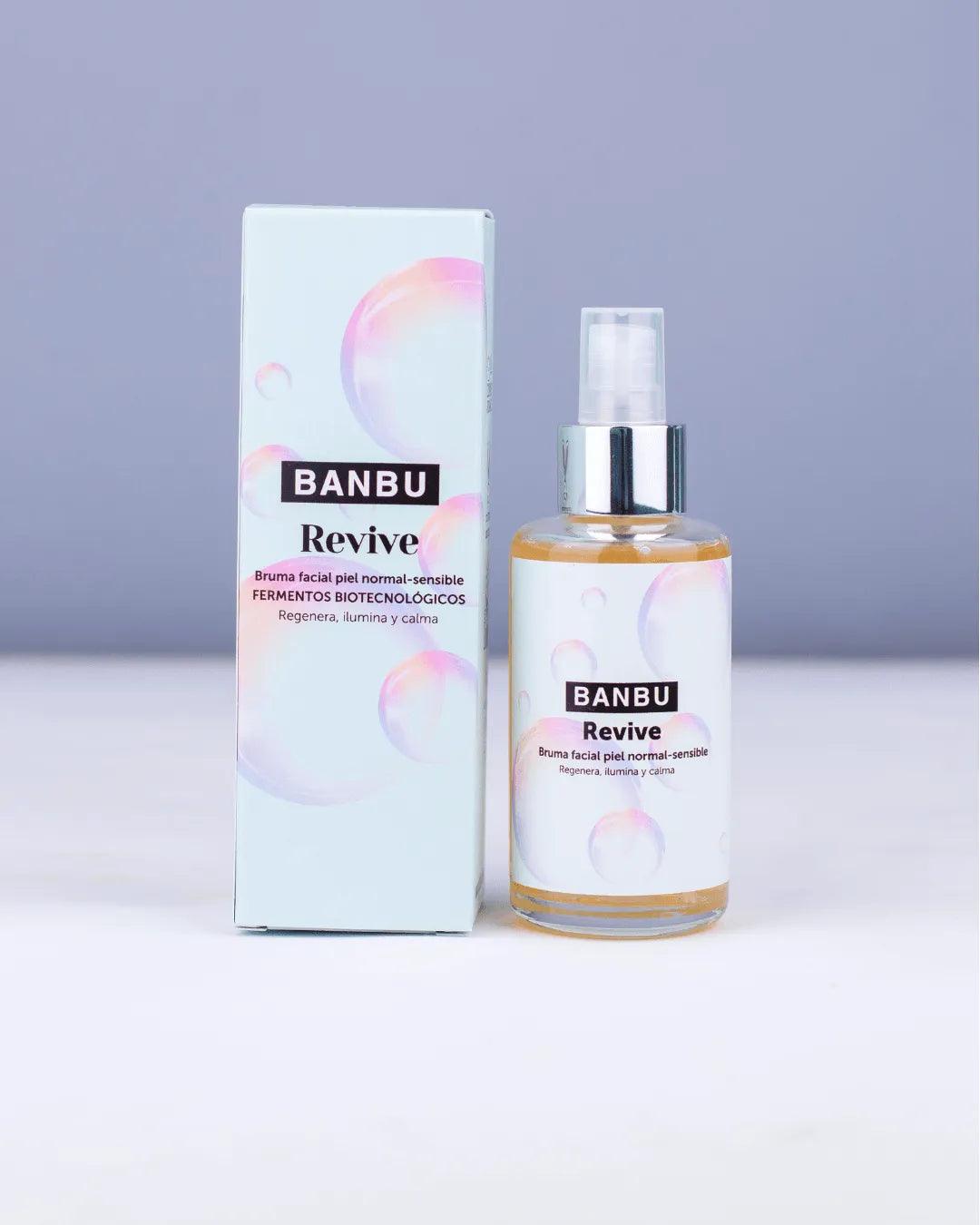 Tónico facial Banbu Revive en envase de cristal y caja azul claro con burbujas iridiscentes sobre fondo suave.