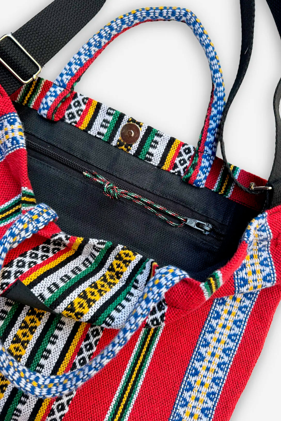 Bolso bandolera de tela con estampado étnico multicolor en rojo, amarillo y verde, cierre de cremallera y botón imán.