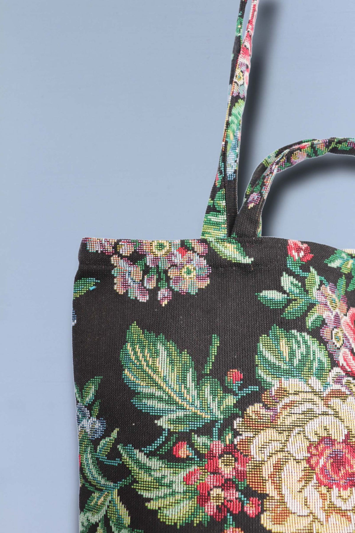 Tote bag de tela negra con tejido jacquard de flores y peonías coloridas, diseño floral estilo clásico con dos asas.