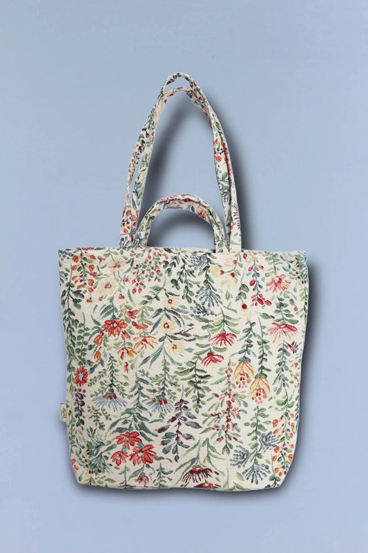 Tote bag de tejido jacquard con estampado de flores y azaleas en tonos vivos sobre fondo claro, asas dobles.