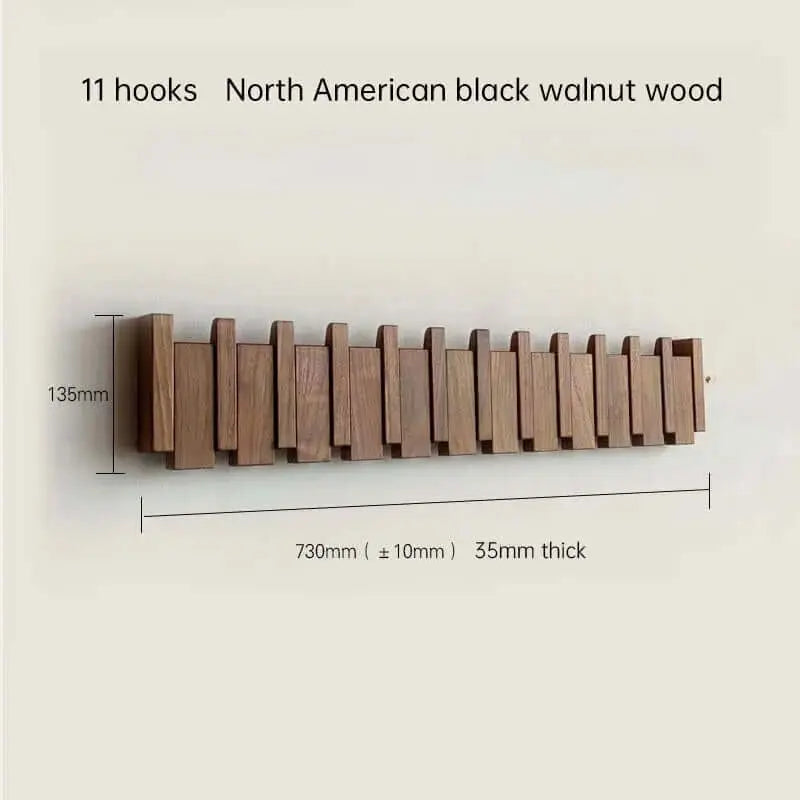 Perchero de pared de madera de nogal estilo escandinavo con 11 colgadores plegables y medidas técnicas sobre fondo claro.