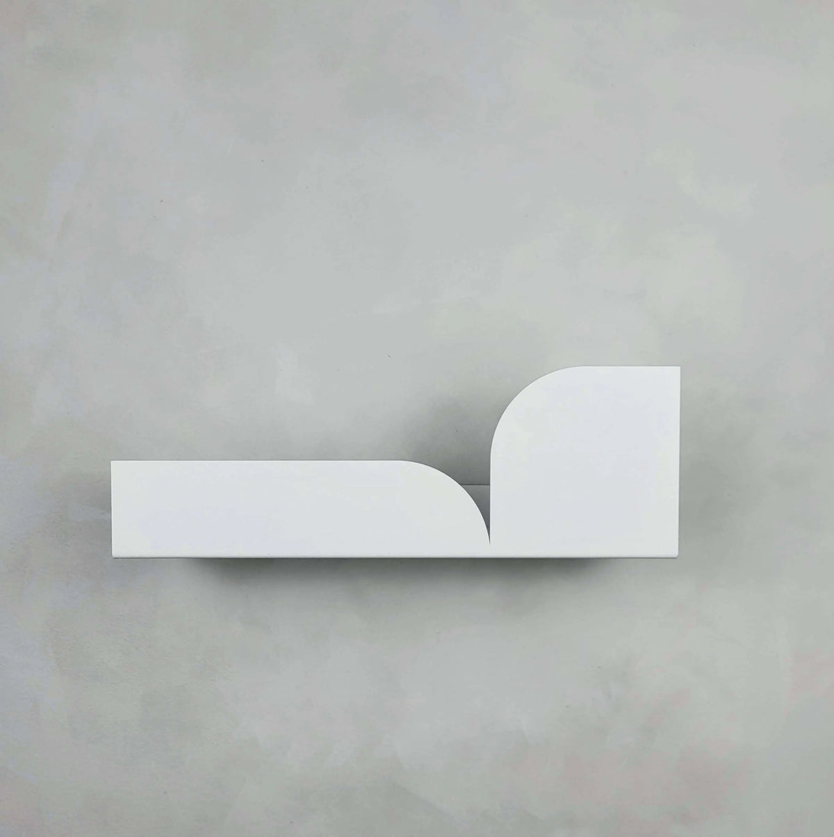 Estante flotante de pared metálico en color blanco, con diseño minimalista de formas curvas y superficie lisa.