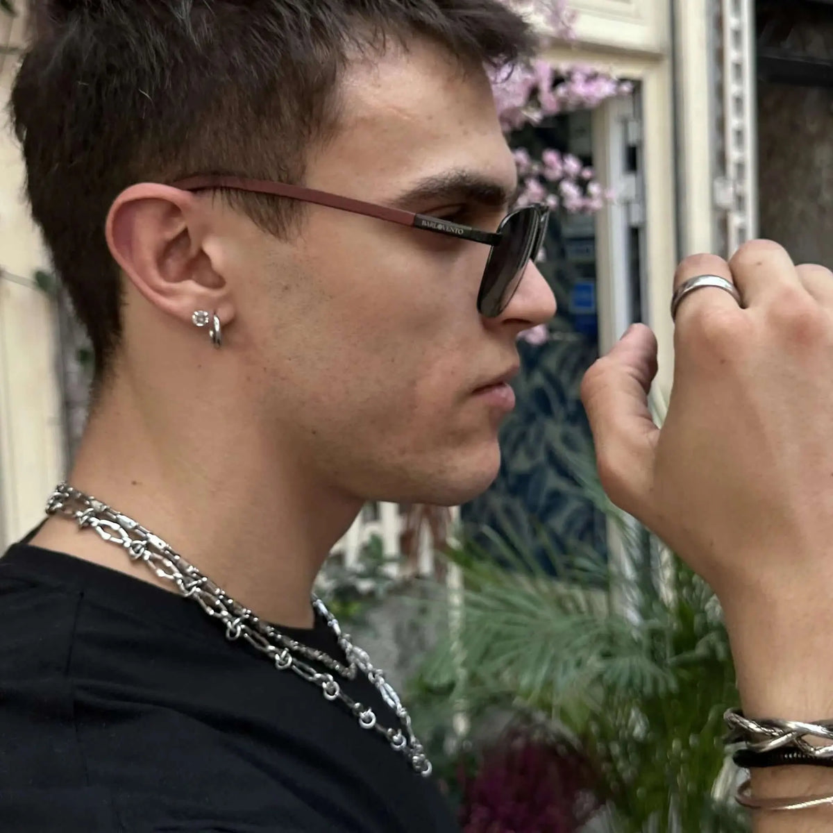 Gafas de sol de montura oscura con patillas de madera marrón, estilo moderno y elegante, puestas de perfil.