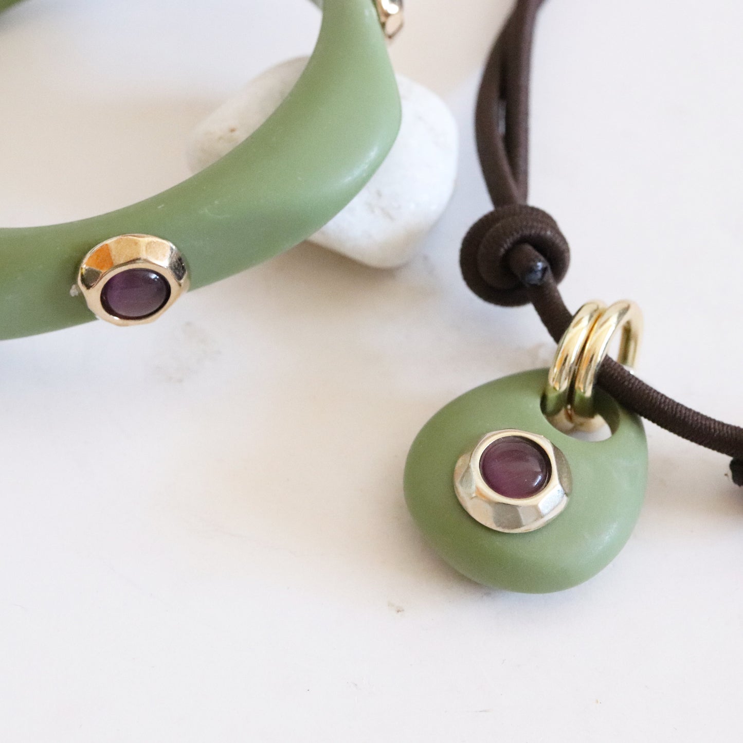 Collar y pulsera de jade verde con detalles dorados y piedras moradas, estilo moderno y elegante.