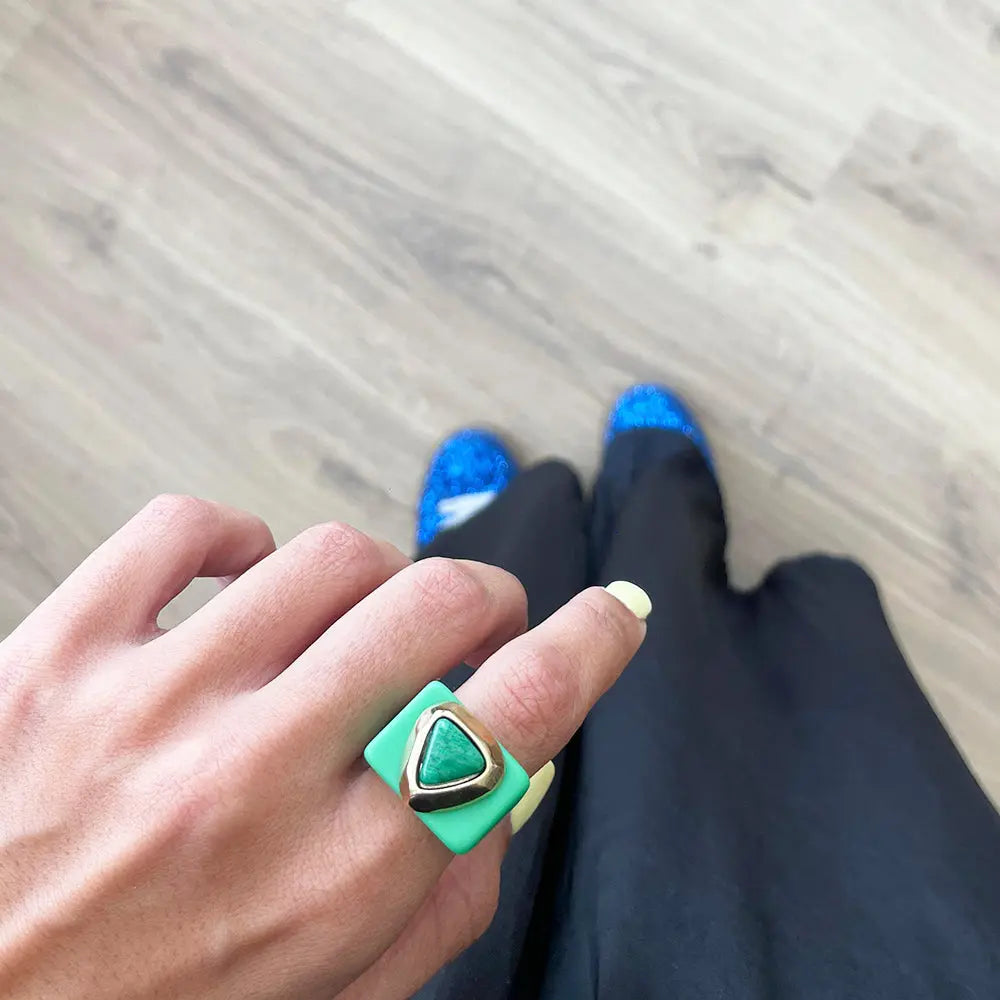 Anillo cuadrado verde con piedra triangular, estilo moderno, ideal para un look elegante.