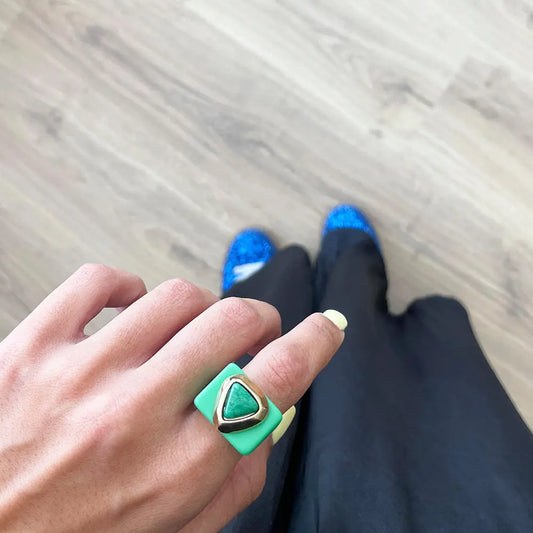Anillo cuadrado verde con piedra triangular, estilo moderno, ideal para un look elegante.