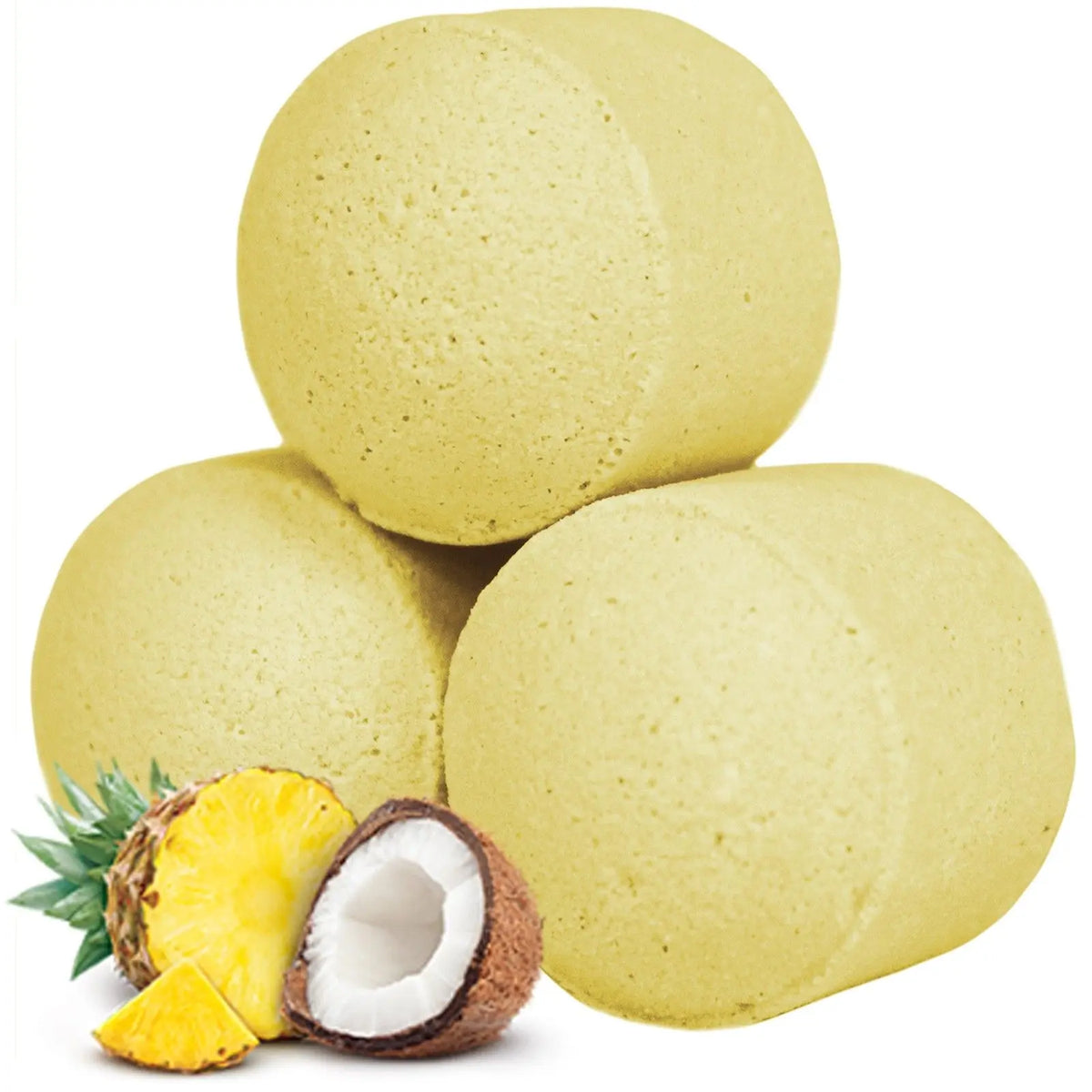 Tres mini bombas de baño amarillas cilíndricas junto a una piña y un coco sobre fondo blanco.