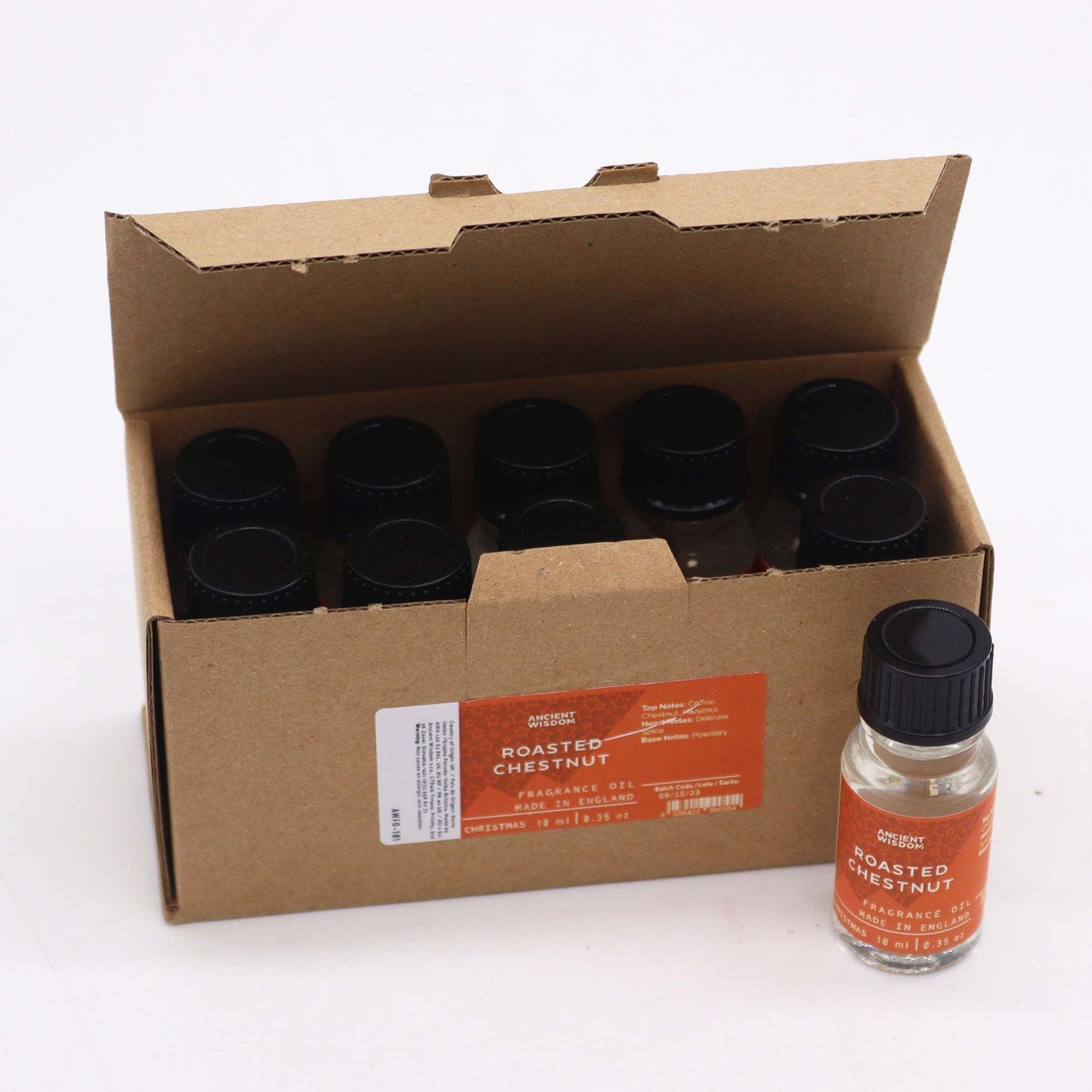 Caja de cartón con varios frascos pequeños de vidrio y tapón negro de aceite de fragancia, uno expuesto al frente.