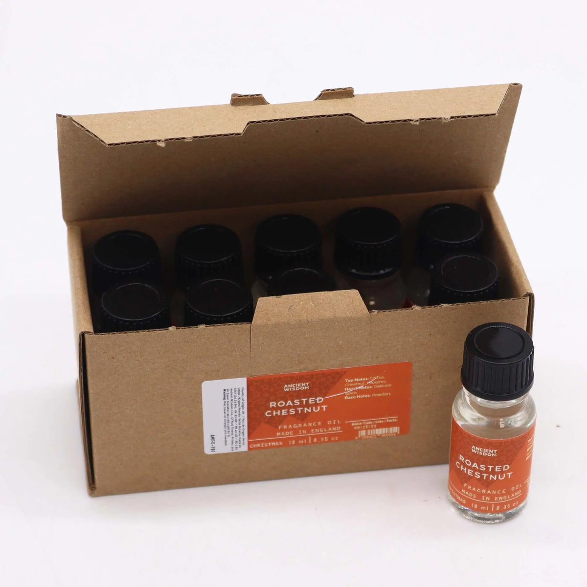 Caja de cartón con varios frascos pequeños de vidrio y tapón negro de aceite de fragancia, uno expuesto al frente.