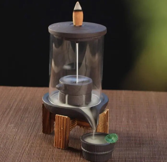 Quemador de incienso de flujo inverso con cúpula de cristal, base de madera y diseño de molino de piedra en cerámica.