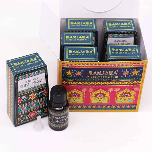 Cajas y frasco de aceite aromático con diseño colorido, estampado floral y motivos geométricos inspirados en la India.