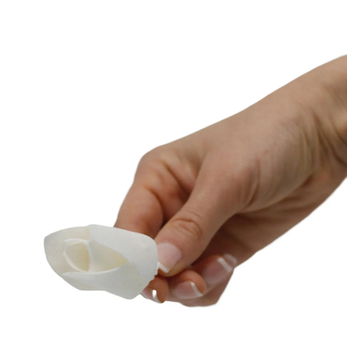 Mano sosteniendo una delicada flor difusora blanca en forma de tulipán hecha de fibra natural sobre fondo blanco