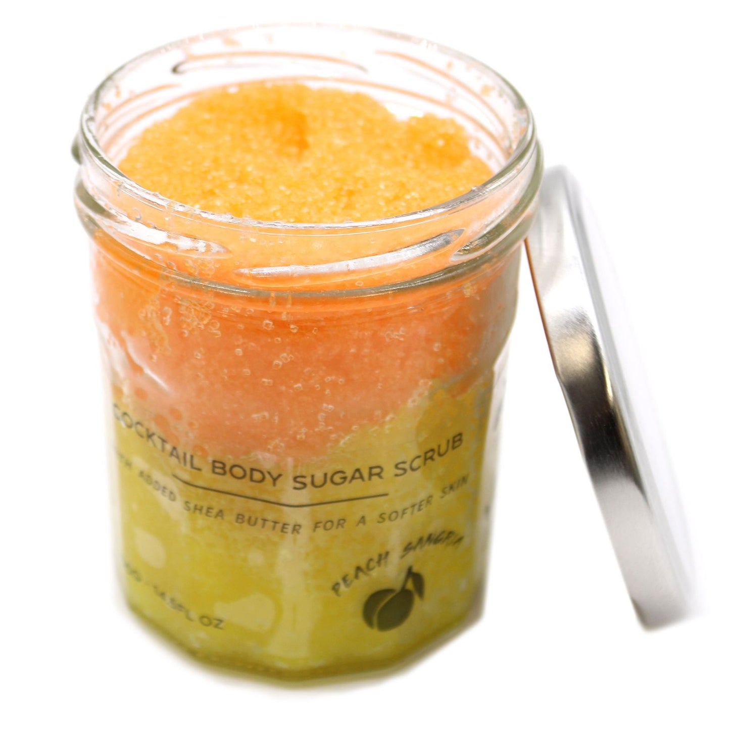 Exfoliante corporal de azúcar en frasco de vidrio con capas naranja y amarilla, tapa metálica a un lado. Fondo blanco.
