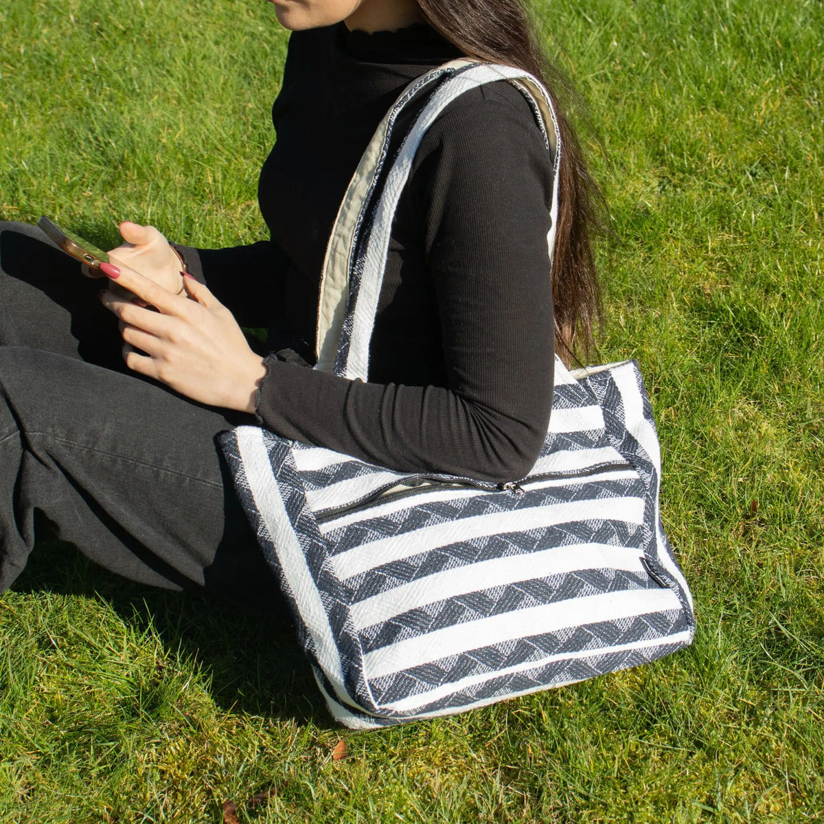 Bolso de tela negro y blanco con rayas, estilo casual, ideal para uso diario, material resistente.