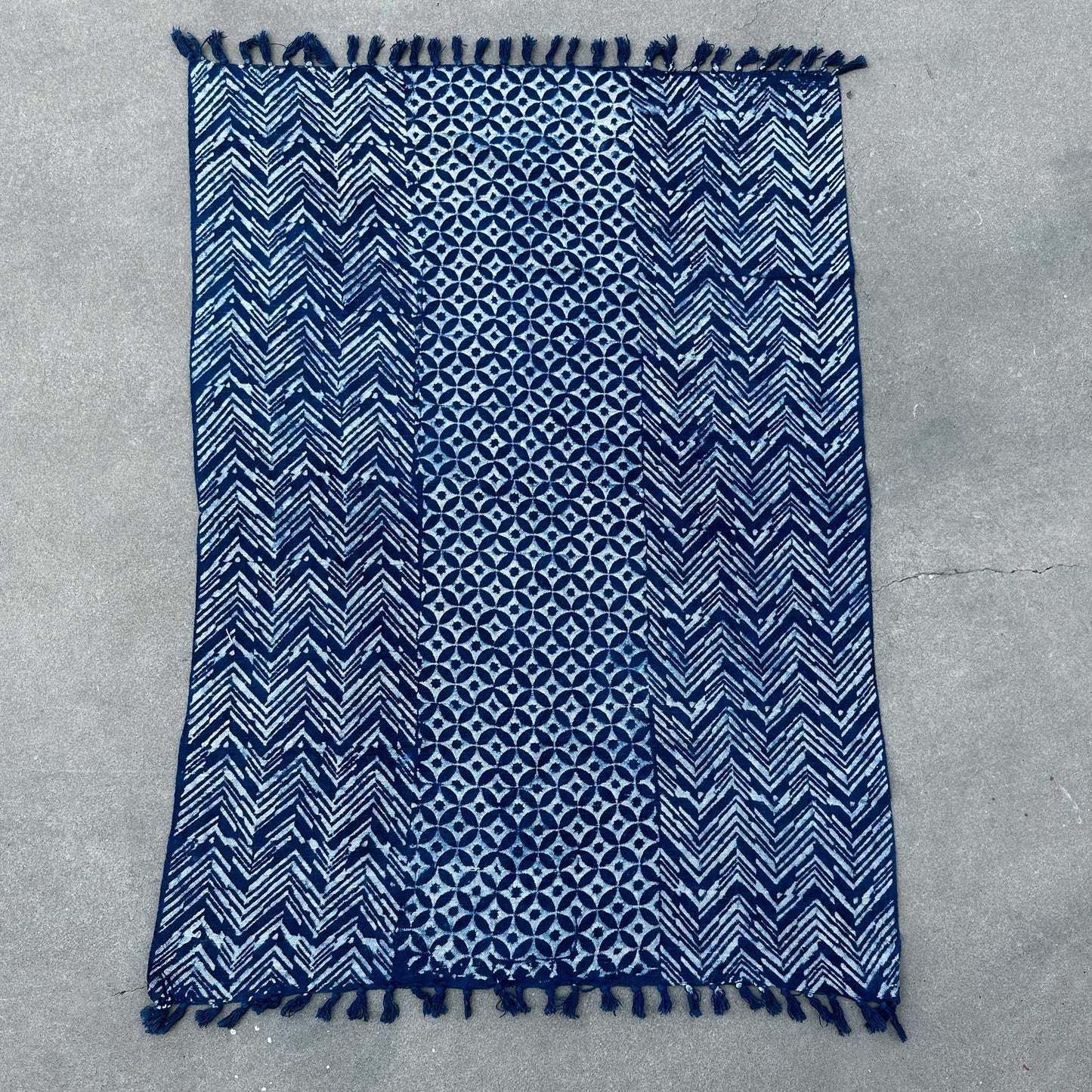 Alfombra azul marino con patrones geométricos y flecos, hecha de algodón, estilo moderno y bohemio.