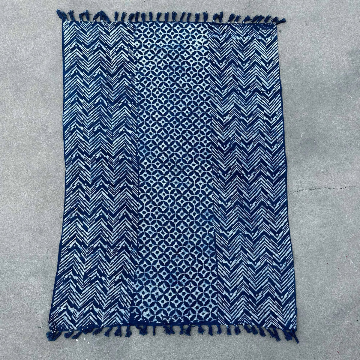 Alfombra azul marino con patrones geométricos y flecos, hecha de algodón, estilo moderno y bohemio.