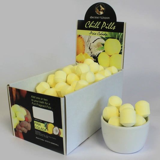 Caja de exhibición con mini bombas de baño amarillas, cilíndricas y efervescentes, aroma a piña colada.
