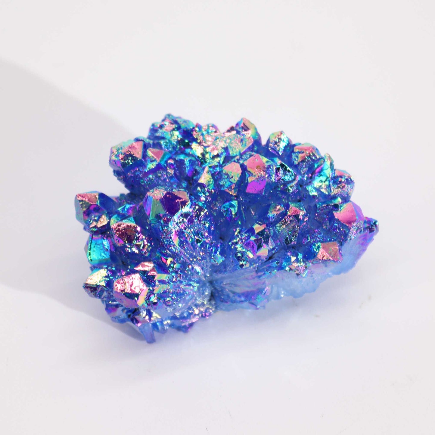 Cristal brillante en tonos azules y púrpuras, con destellos iridiscentes, ideal para decoración o coleccionismo.