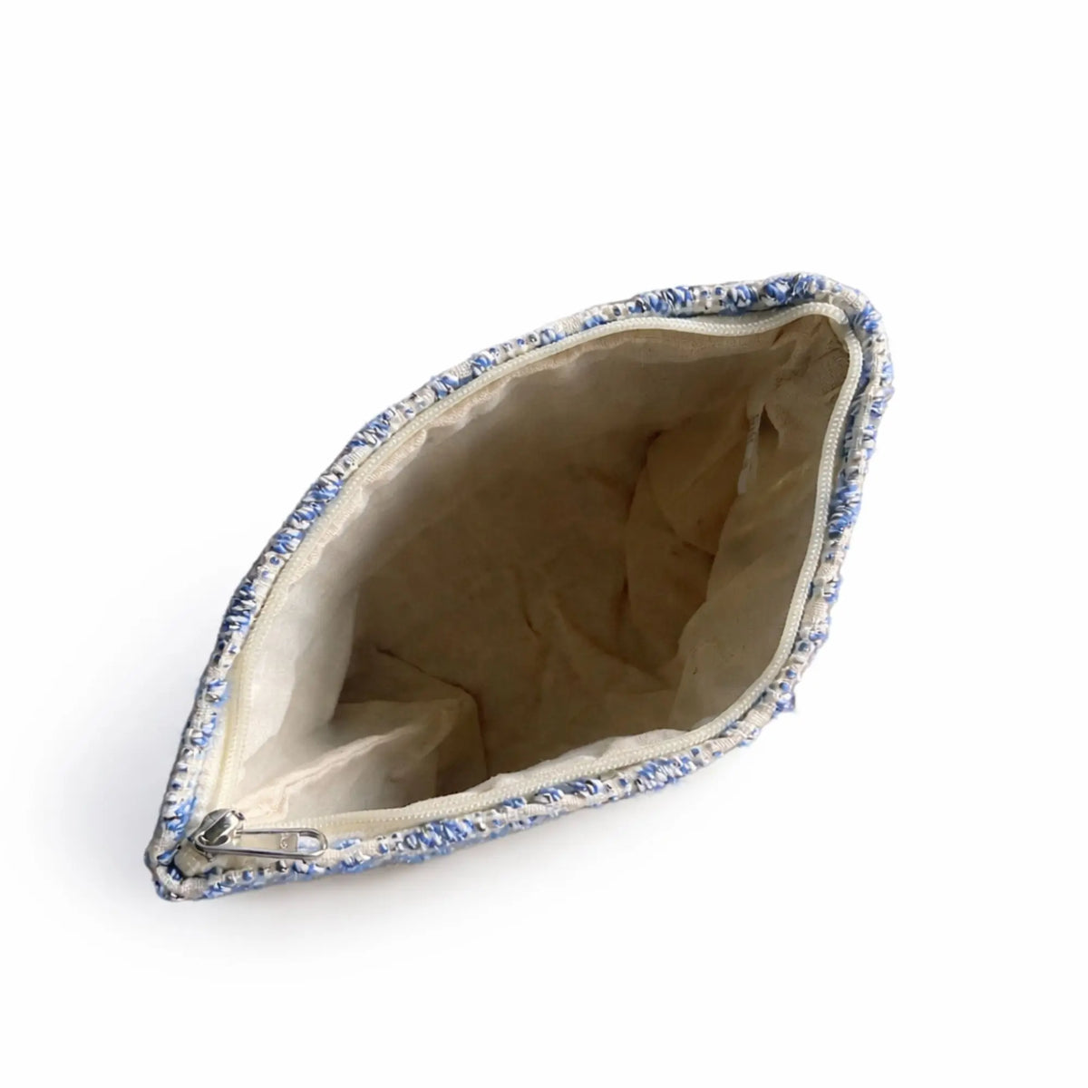 Bolso de mano azul con textura de tela y forro interior beige, bolso elegante y práctico para uso diario.