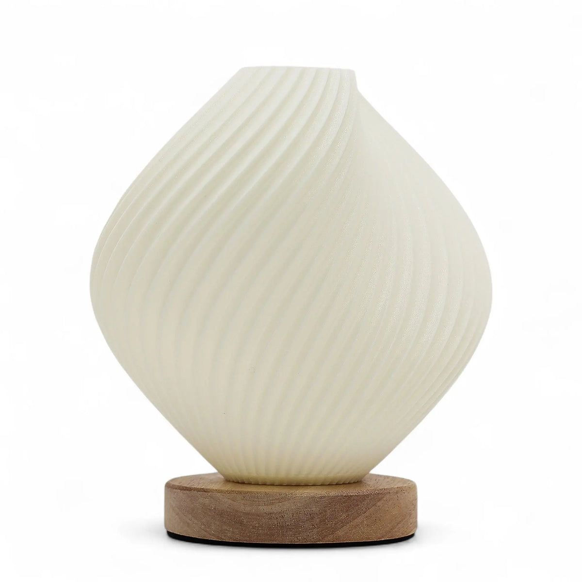 Lámpara de mesa blanca con forma de concha espiral sobre una base redonda de madera natural. Fondo blanco.