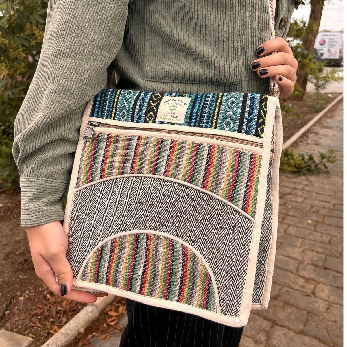 Bolso mensajero de cáñamo con diseño de curvas, texturas tejidas multicolores y base gris con patrón de espiga.
