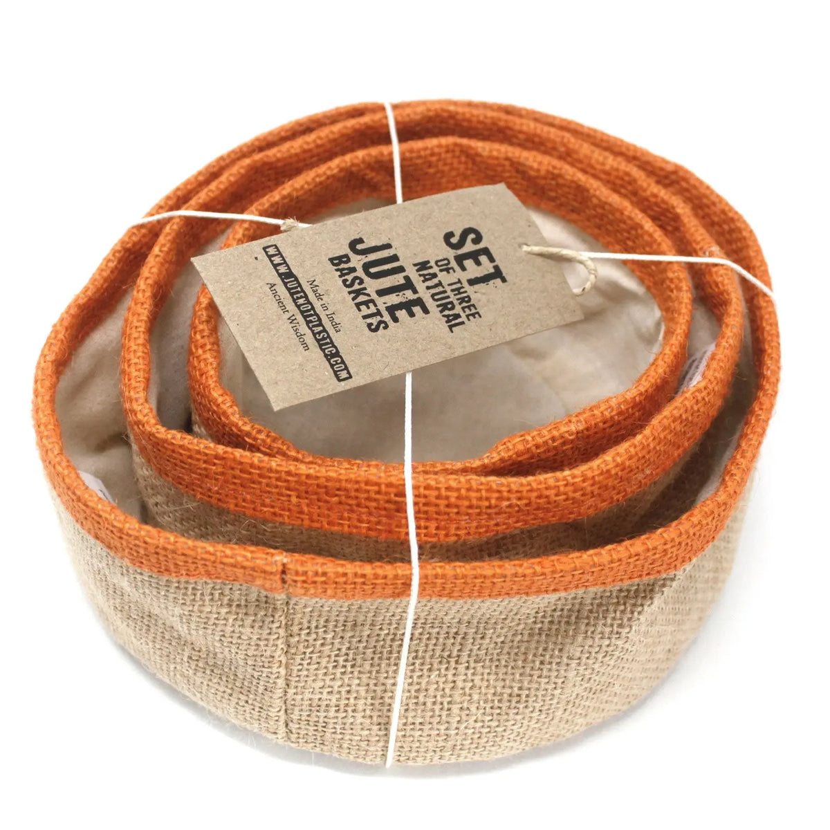 Conjunto de tres cestas redondas de yute natural con borde color cúrcuma, apiladas y con una etiqueta de cartón.