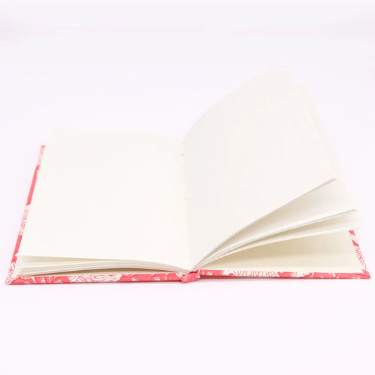 Cuaderno abierto de 20x15cm con tapa de tela de algodón rosa floral y páginas de papel color crema.