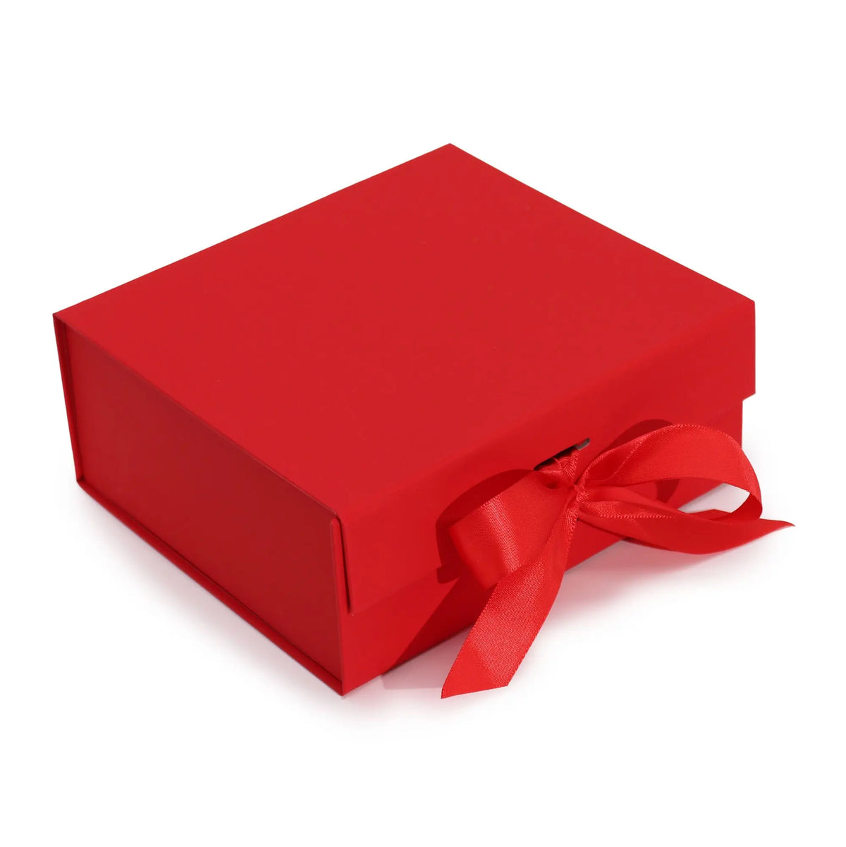 Caja de regalo rectangular roja, plegable, con tapa y un elegante lazo de cinta roja en el frente. Fondo blanco.