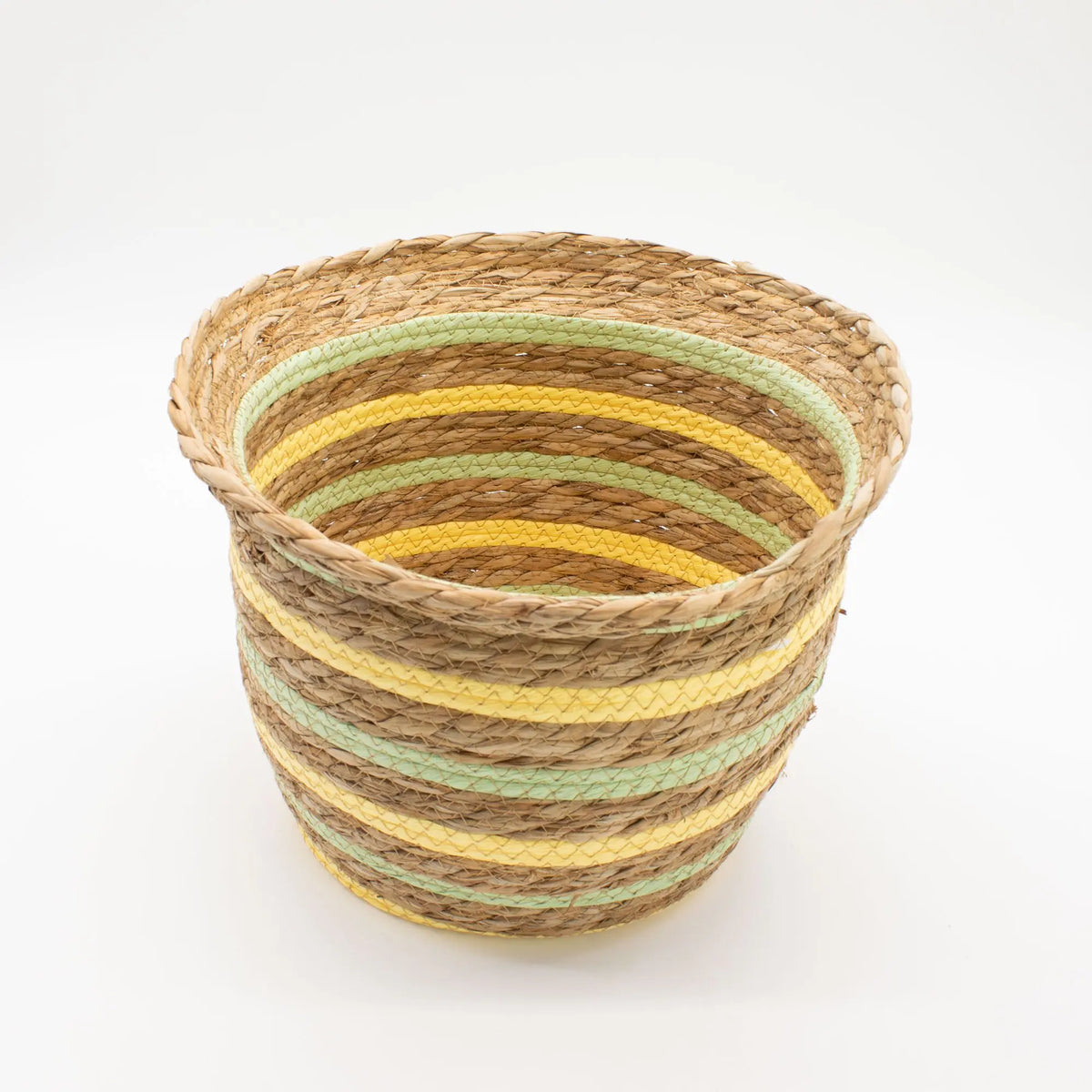 Cesta artesanal con forma de jarrón, tejida en hierba marina con rayas decorativas en tonos amarillo y verde claro.