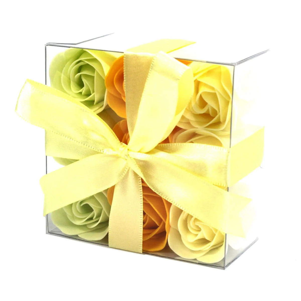 Caja transparente con 9 rosas de jabón en tonos amarillo, naranja y verde, decorada con un lazo de cinta amarilla.