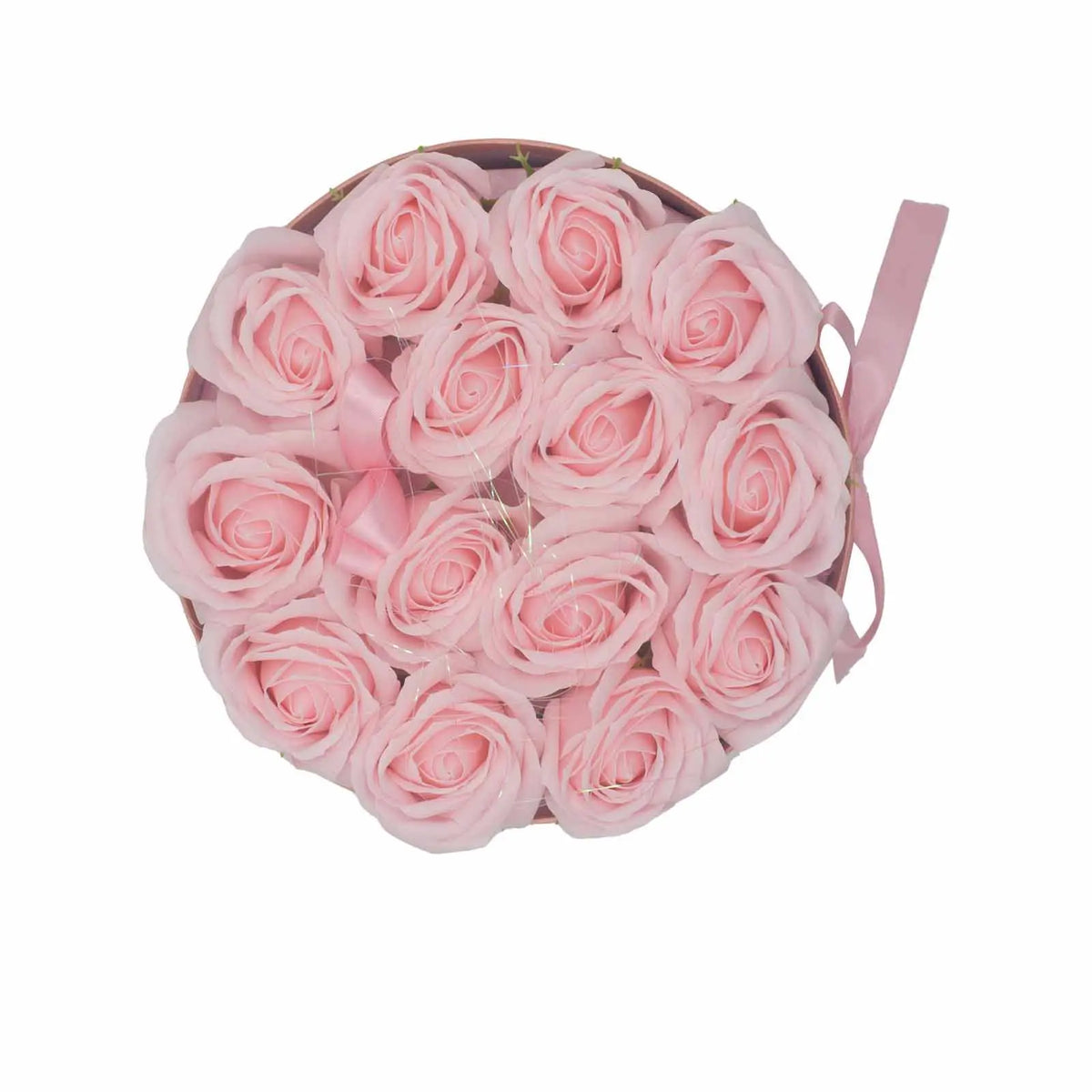 Caja redonda con 14 rosas de jabón color rosa claro y lazo decorativo a juego, vista cenital sobre fondo blanco.