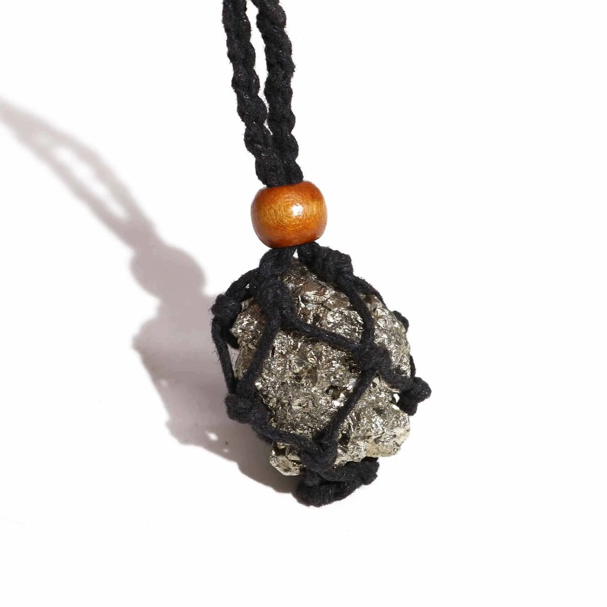 Collar de cordón negro tejido con red que sostiene una piedra dorada rugosa y una cuenta de madera sobre fondo blanco.