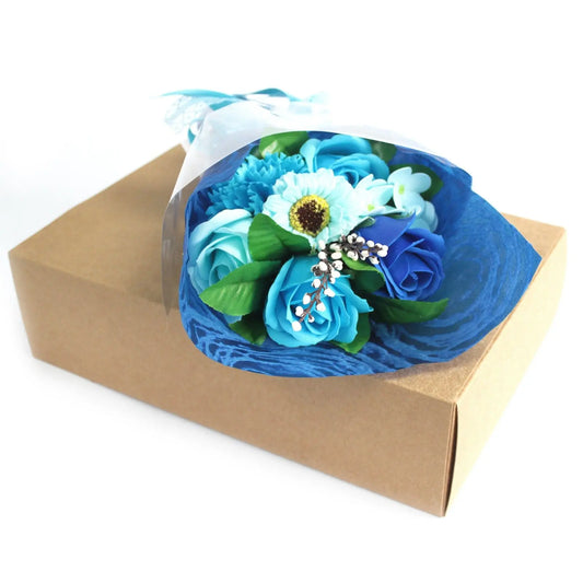 Bouquet de flores de jabón en tonos azules sobre una caja rectangular de cartón kraft decorativa.