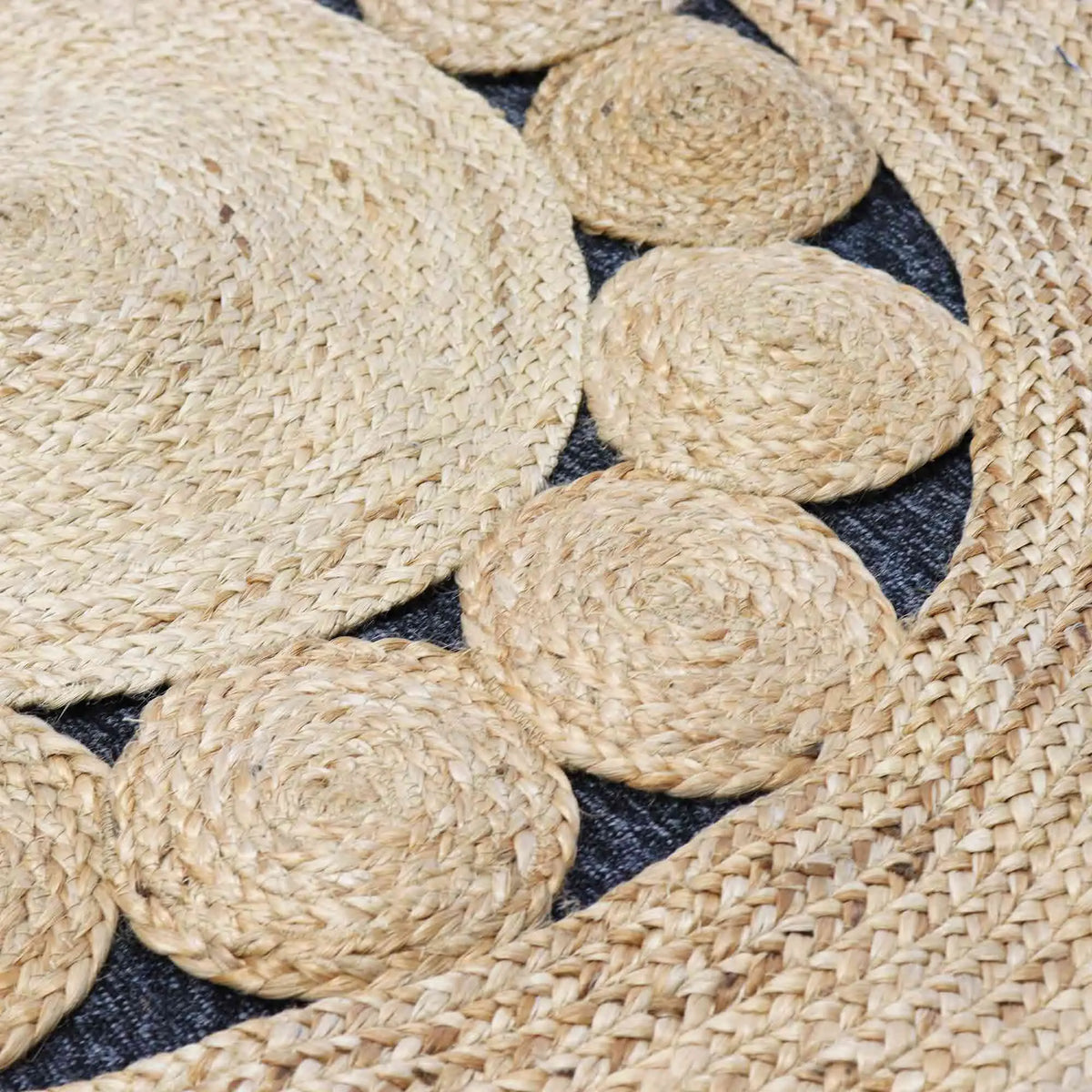 Alfombra redonda de yute natural y algodón gris con círculos trenzados entrelazados en relieve, estilo artesanal.