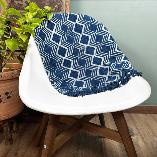 Manta azul con diseño geométrico en algodón, ideal para decorar y abrigar, con flecos y textura suave.