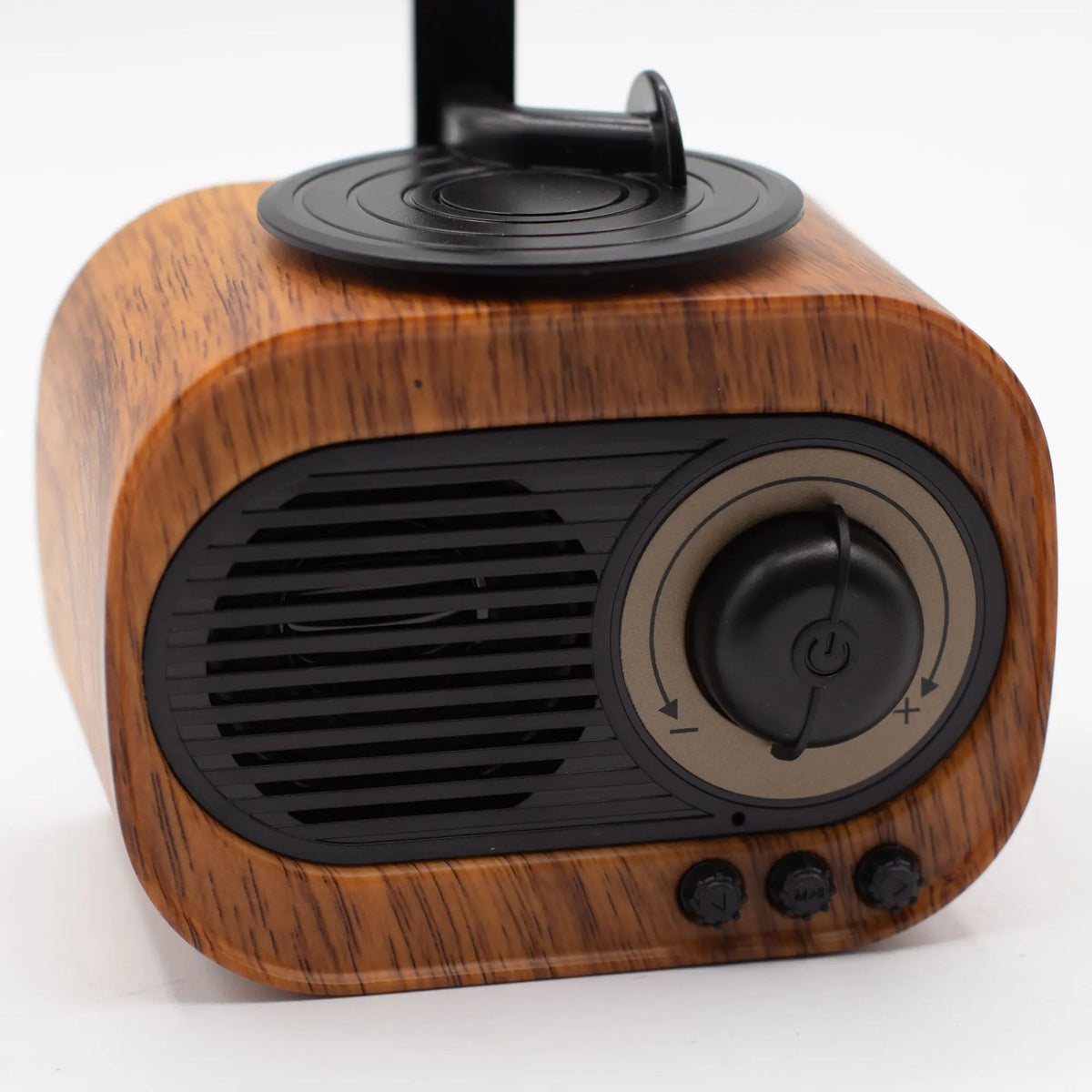 Altavoz Bluetooth retro con acabado de madera, diseño de minigramófono, perilla central y controles negros sobre fondo.