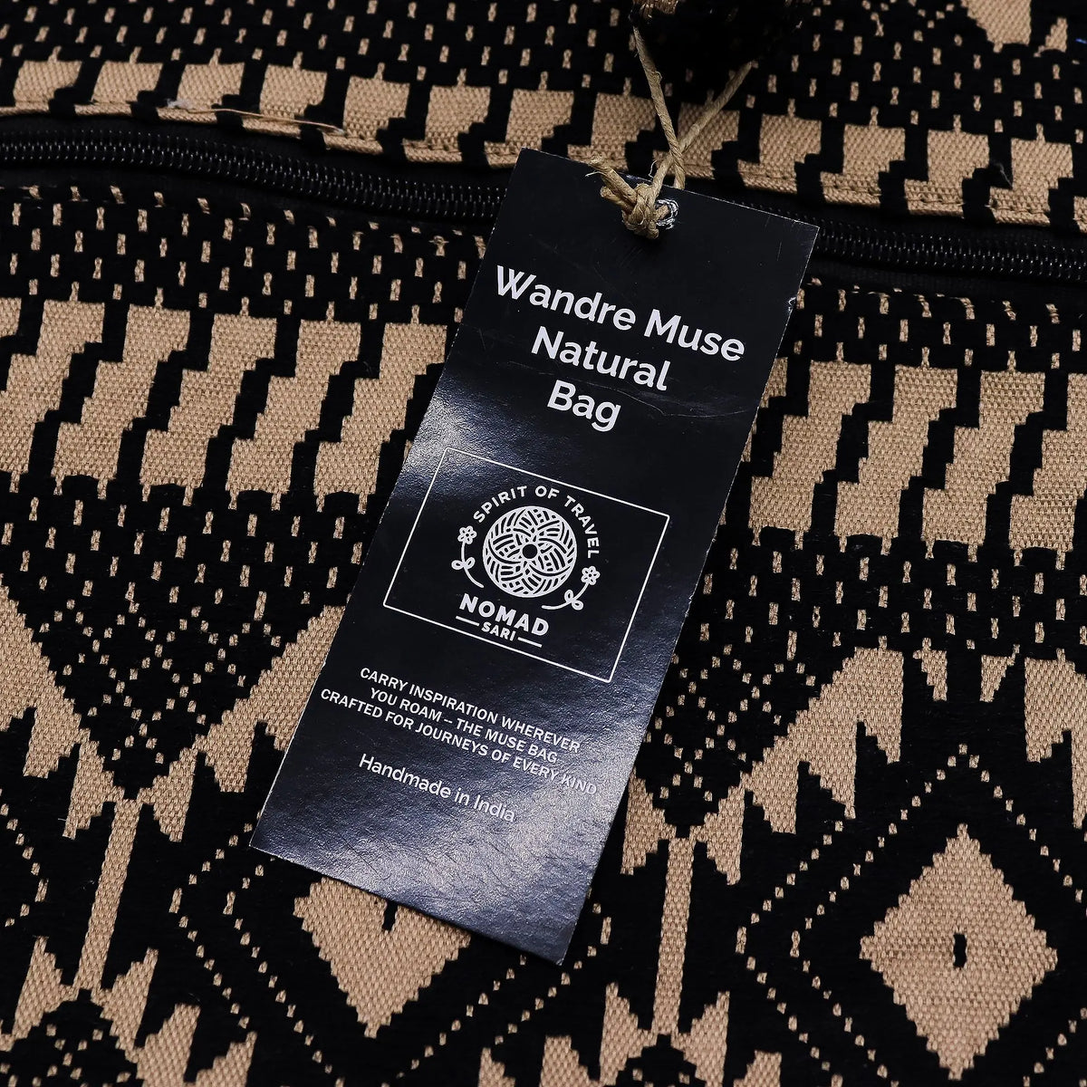 Bolsa natural Wandre Muse, hecha a mano en India, con diseño geométrico en negro y beige. Perfecta para viajes.