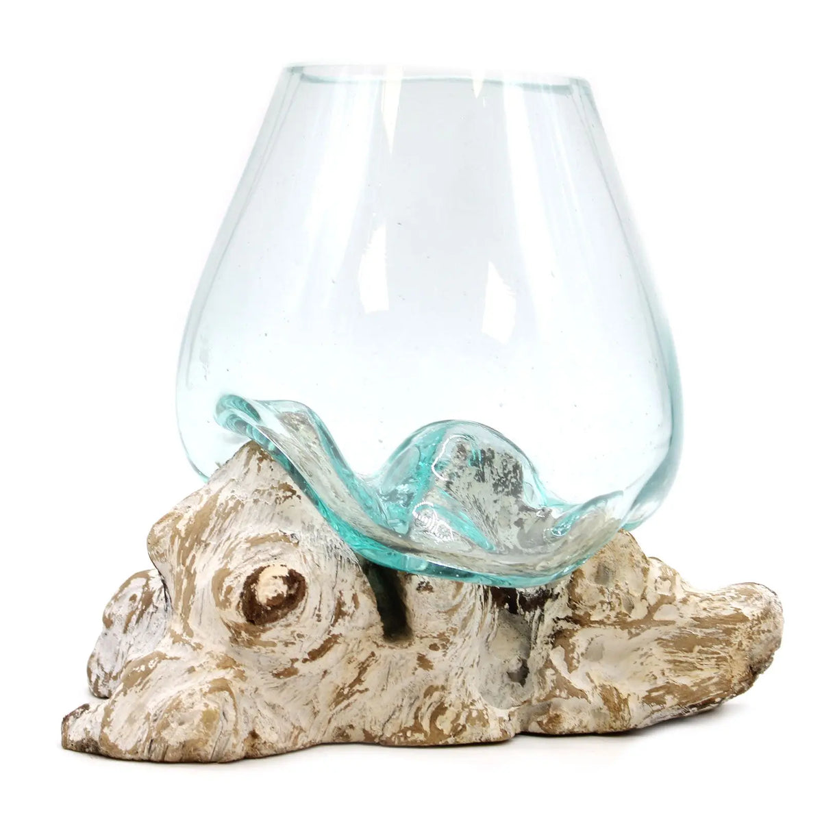 Cuenco de vidrio fundido transparente moldeado sobre una pieza de madera natural blanqueada de estilo rústico.