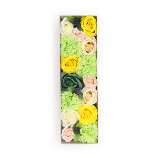 Caja rectangular con rosas y flores de jabón en tonos amarillo, verde y melocotón con detalles de hojas decorativas